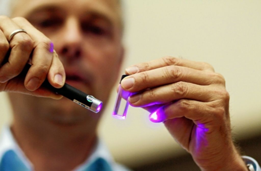 Der Physiker Jörg Wrachtrup von der Uni Stuttgart leuchtet bei der Leser-Uni der Stuttgarter Zeitung mit einem Laserpointer auf einen winzigen Diamanten. 